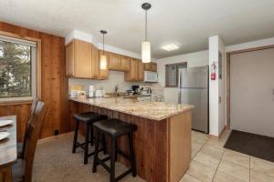 a kitchen with wooden cabinets and a counter top with stools at Beaver Village Unit #0724 in Winter Park