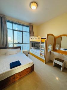 Sand And Beachfront Havens with sea view&pool&Gym&jacuzz في عجمان: غرفة نوم بسريرين بطابقين ونافذة كبيرة +128 صورة