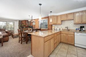 a kitchen with wooden cabinets and a dining room at Beaver Village Unit #0724 in Winter Park +20 photos