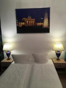 a bedroom with a bed with two lamps on tables at Hotel-Pension Adamshof in Berlin