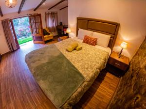 a bedroom with a large bed with two stuffed animals on it at Kay Pacha Wellness Place Eco in Ayacucho +87 photos