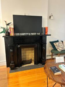 a living room with a fireplace with a television on top at Sunny Private Room with Terrace in Bed-Stuy, Brooklyn in Brooklyn
