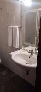 a bathroom with a sink and a mirror and towels at Lavanda Termas de São Pedro do Sul in Bicas