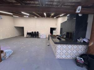 an empty room with a counter and chairs in it at Chácara Tubaras in Uberlândia +13 photos