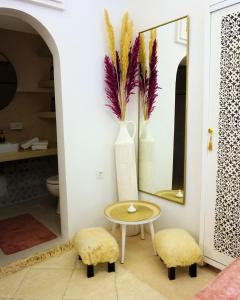 a room with a table and two stools and a mirror at Little date in Marrakech