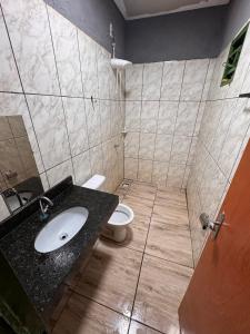 a bathroom with a sink and a toilet at Chácara Tubaras in Uberlândia