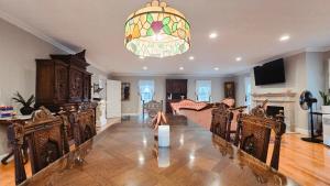 een woonkamer met een tafel en stoelen en een kroonluchter bij Luxury Retreat in Buzzards Bay, Spa, Pool Table for Family Fun in Bourne +82 foto's
