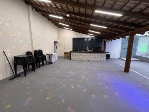 a room with a stage and chairs and a projection screen at Chácara Tubaras in Uberlândia