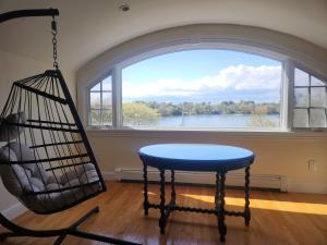 een schommel in een kamer met een groot raam bij Luxury Retreat in Buzzards Bay, Spa, Pool Table for Family Fun in Bourne