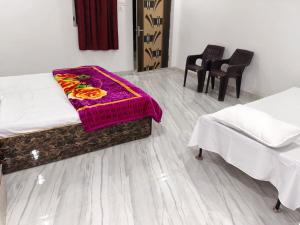 a room with two beds with a purple blanket at Manglam House in Ayodhya