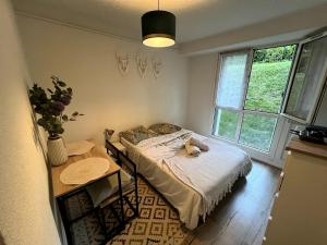 a bedroom with a bed and a table and a window at Studio Cozy in Larue