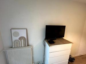 a tv sitting on top of a dresser next to a wall at Studio Cozy in Larue