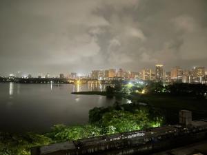 a city skyline at night with a large body of water at Breezy Brown Spacious 2 BHK Lake View in Mumbai