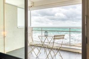 a balcony with a table and a view of the ocean at Studio Premium Face Océan, Balcon & Piscine in Les Sables-d'Olonne