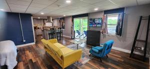 - un salon avec un canapé jaune et deux fauteuils bleus dans l'établissement Morabeza - A Tropical Seneca Haven, à Burdett