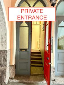 Eine rote Tür mit einem Schild mit der Aufschrift „Privateingang“ in der Unterkunft Melrose Place in Helsinki