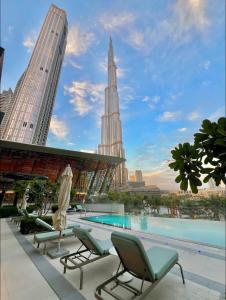 a view from the rooftop of a building with chairs and a swimming pool at Luxury 2BR Sea Burj views Khalifa infinity pool in Dubai