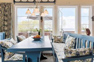 ein Esszimmer mit einem blauen Tisch, Stühlen und Fenstern in der Unterkunft 3690 Nexø - Hovedgade 2 in Snogebæk