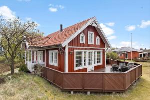 ein kleines rotes Haus mit einer großen Terrasse in der Unterkunft 3690 Nexø - Hovedgade 2 in Snogebæk + 17 Fotos