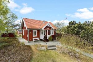 ein kleines rotweißes Haus mit einer Veranda in der Unterkunft 3690 Nexø - Hovedgade 2 in Snogebæk