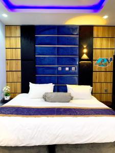 Dreamville Hotel & Resort في أويو: غرفة نوم بسرير كبير مع لوح رأس أزرق