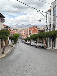 una calle de la ciudad con coches estacionados al costado de la carretera en Casa de Liz Homestay, en Sucre