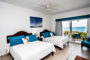 zwei Betten in einem Zimmer mit Meerblick in der Unterkunft Agualina Kite Hotel in Cabarete