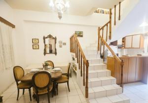 a dining room with a table and chairs and a staircase at Characterful 2-Bed Home in Peaceful Town Near Agios Nikolaos in Neápolis