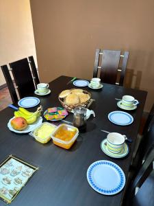 Una mesa negra con platos y comida azules y blancos. en Casa de Liz Homestay, en Sucre