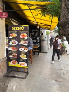 un hombre parado frente a un puesto de comida en Casa de Liz Homestay, en Sucre