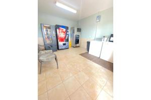 a room with a soda machine and a refrigerator at Weslaco Inn by Capital O Near Mercedes in Weslaco
