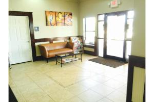 a living room with a couch and a glass table at Weslaco Inn by Capital O Near Mercedes in Weslaco