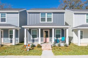 a gray house with a pink door at Stylish, BRAND NEW 3 Bed Cottage, Beach Front, DOG FRIENDLY! in Beauvoir