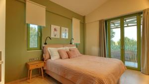 a bedroom with a bed and a large window at Alkyoni luxury apartments Katakolo in Katakolon