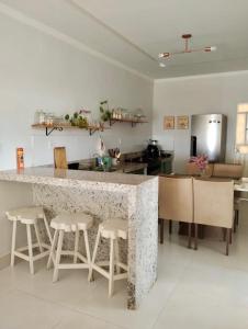 eine Küche mit einer Theke mit Hockern drum herum in der Unterkunft Casa Vieira in Piranhas