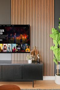 Una sala de estar con un televisor en la pared. en Stylish 2br High-Rise - Sleeps 7 - YYZ, en Mississauga