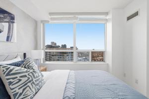 Un dormitorio con una cama y una ventana grande. en Stylish 2br High-Rise - Sleeps 7 - YYZ, en Mississauga