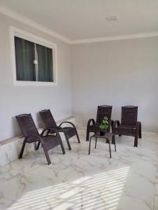 eine Gruppe von Stühlen in einem Raum mit einem Fenster in der Unterkunft Casa Vieira in Piranhas