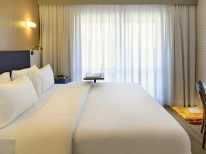 a large white bed in a hotel room with a window at Mercure Sao Bernardo Do Campo in São Bernardo do Campo +83 photos