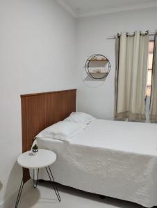 ein weißes Schlafzimmer mit einem Bett und einem Tisch in der Unterkunft Casa Vieira in Piranhas