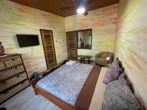 ein Schlafzimmer mit einem Bett, einer Kommode und einem Fernseher in der Unterkunft Sango beach in Accra + 16 Fotos