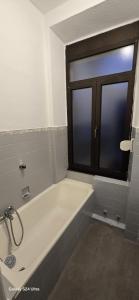 a bathroom with a bath tub and a window at Homeday joffre 2 type F2 Haguenau in Haguenau +5 photos