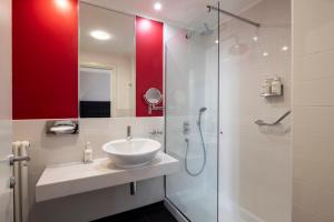 a bathroom with a sink and a shower at Holiday Inn Genoa City by IHG in Genoa