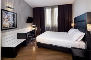 a hotel room with a bed and a desk at Holiday Inn Genoa City by IHG in Genoa