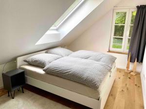een slaapkamer met een bed met kussens en een raam bij Ferienhaus Waldblick in Warendorf