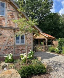 een bakstenen huis met een boom ervoor bij Ferienhaus Waldblick in Warendorf