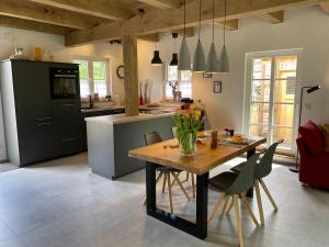 een keuken met een houten tafel met stoelen en een eetkamer bij Ferienhaus Waldblick in Warendorf