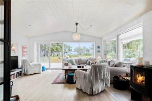 Una sala de estar con un sofá y una chimenea. en 3670-Nexo-Odden-11, en Bedegård