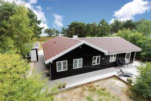 una casa negra con porche y terraza en 3670-Nexo-Odden-11, en Bedegård