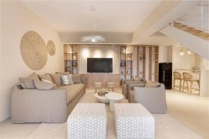 Una sala de estar con un sofá y un televisor. en Villa Levantina, en Porto Heli